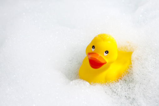 A cheerful yellow rubber duck in a bathtub full of soapy bubbles.See similar: