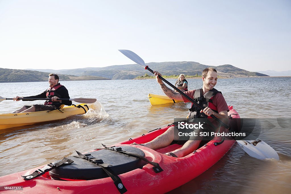 Feliz kayakers remo en un lago - Foto de stock de Actividad libre de derechos