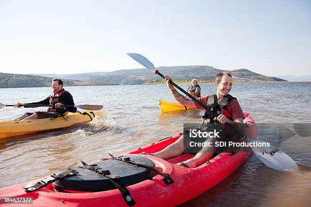 Feliz Kayakers Remo En Un Lago Foto de stock y más banco de imágenes de Actividad - Actividad, Actividad al aire libre, Actividades recreativas