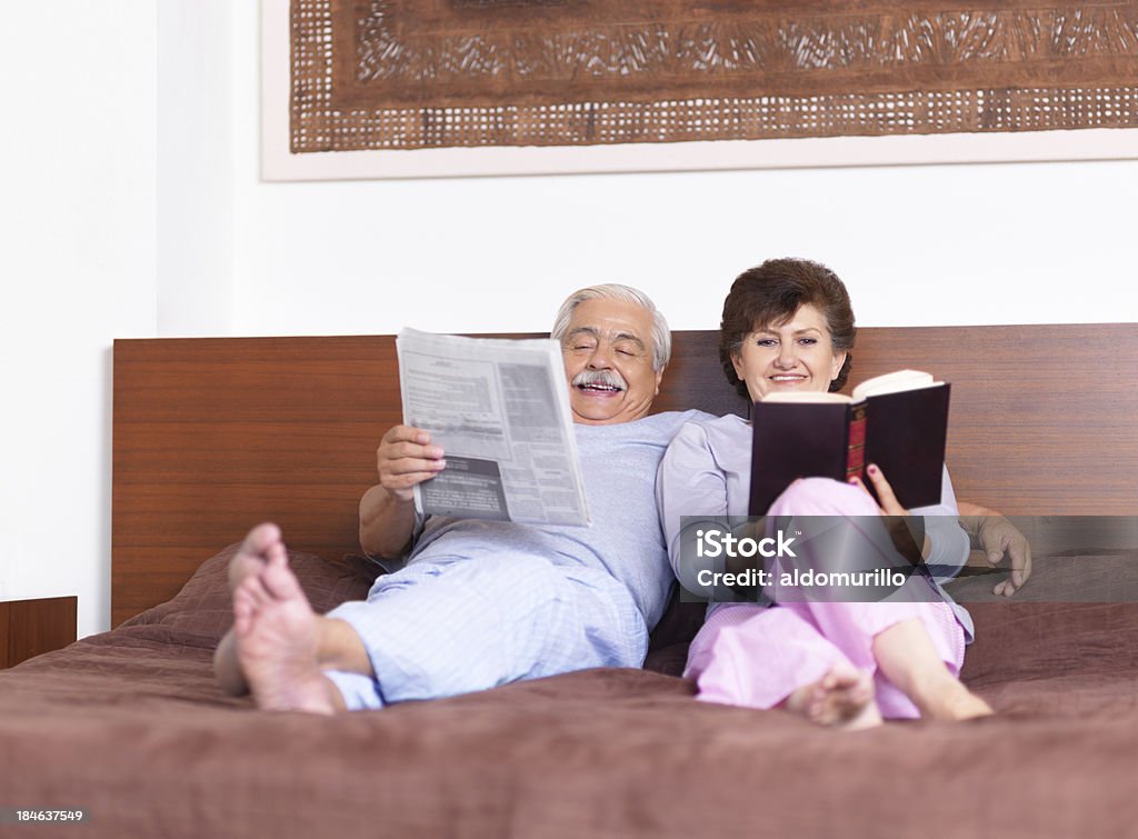 Пожилая пара, чи�тать в постели - Стоковые фото 60-64 года роялти-фри