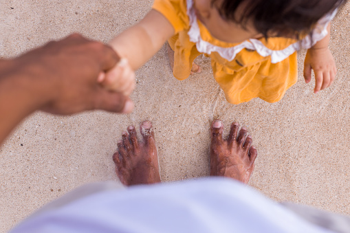 Moment of family with a toddler during vacation on the beach - Stock photo