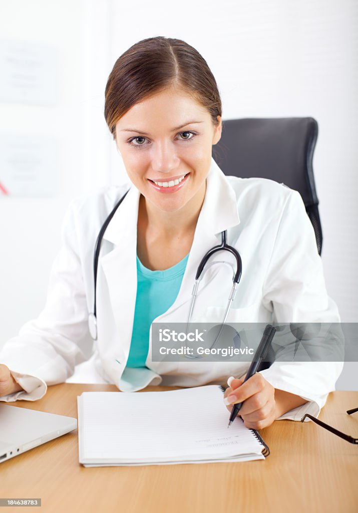 Nurse in office Young nurse working in office on laptop. Adult Stock Photo