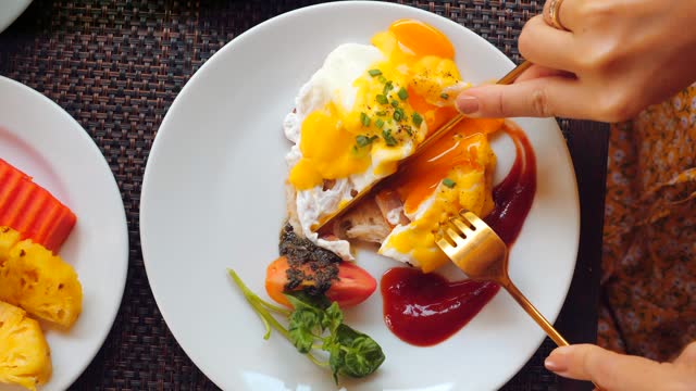 Woman enjoying balanced breakfast with eggs, fresh vegetables