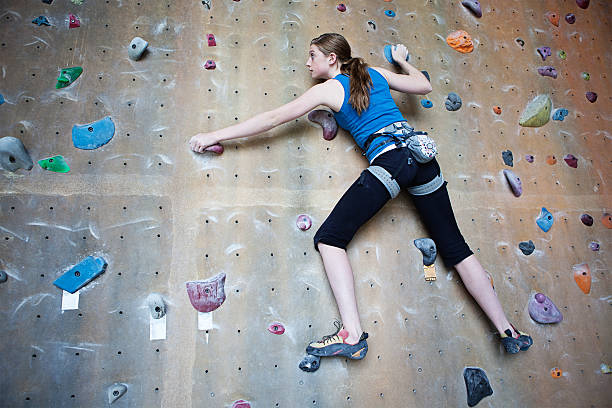 young rock climber climbing on wall