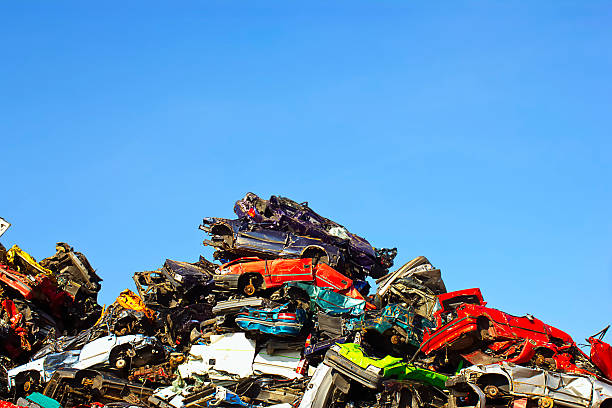 Scrapyard Scrapyard with crushed colorful cars with a blue sky in the background. junkyard photos stock pictures, royalty-free photos & images