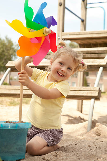 istock Preschooler looking at toy in sandbox. 184639462