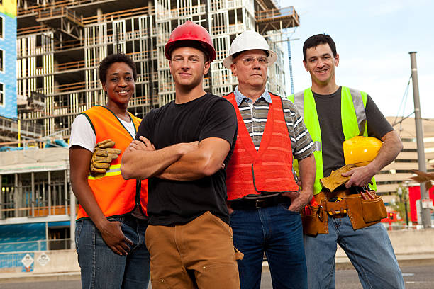 istock Four construction workers standing in front of a building site. 184639493