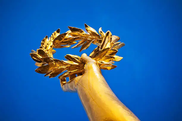 "Close-up shot of Statue of Victoia's hand holding the Gold Laurel. The statue is on top of Victory Column, a monument erected 1864 in Berlin (Tiergarten) to commemorate the Prussian victory in the Danish-Prussian War."
