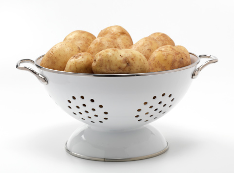 colander filled with raw potatoes