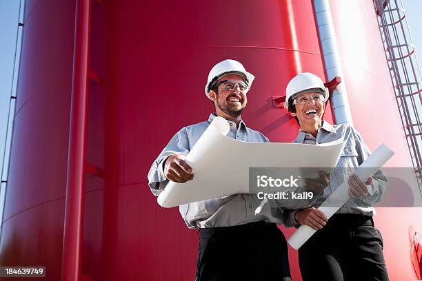 Photo libre de droit de Travailleurs Debout Par Industriel Avec Des Plans De La Water Tower banque d'images et plus d'images libres de droit de Deux personnes