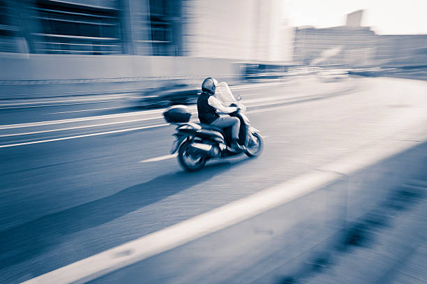 Motorcyclist running in a Milan road during rush hour at sunset. The photo has been taken during iStockalypse 2011 in Milan.