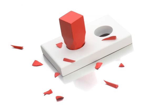 Broken red square peg going into round hole stock photo