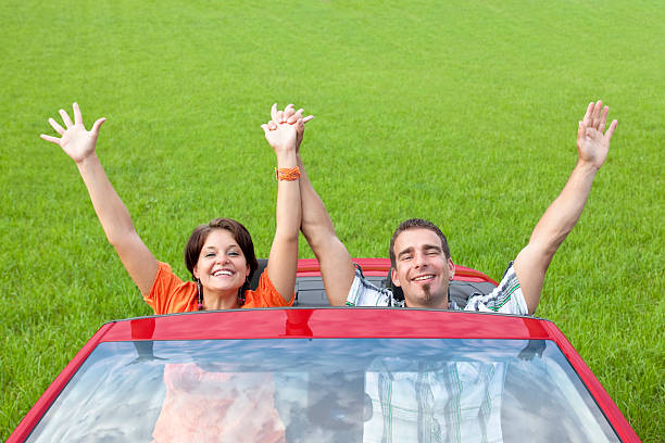 istock Couple with hands up in red cabriolet 184640421