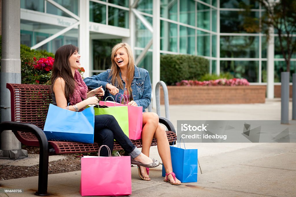 Due giovani donne felice con sacchetti in centro commerciale - Foto stock royalty-free di Fare spese