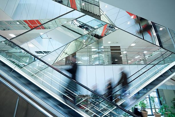 pessoas em dois cruzados escadas rolantes, com distorção de movimento - futuristic indoors inside of abstract - fotografias e filmes do acervo