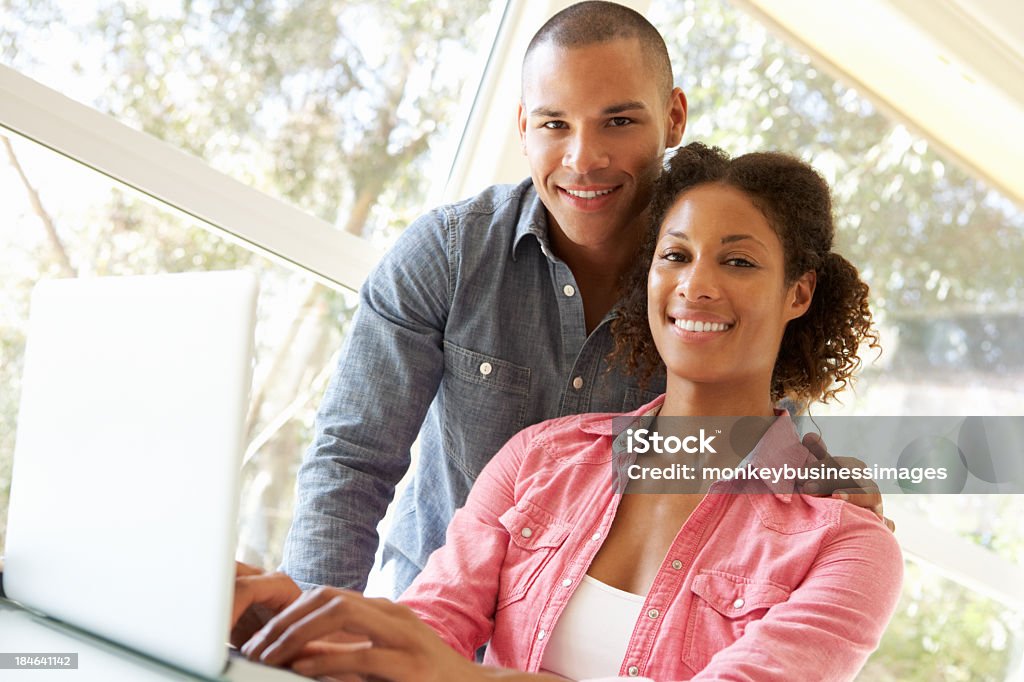 Jeune Couple à l'aide d'ordinateur portable à la maison - Photo de Regarder libre de droits