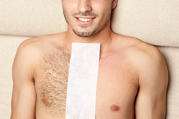 Portrait of man lying with Wax paper on his chest at waxing treatment-before & after waxing.