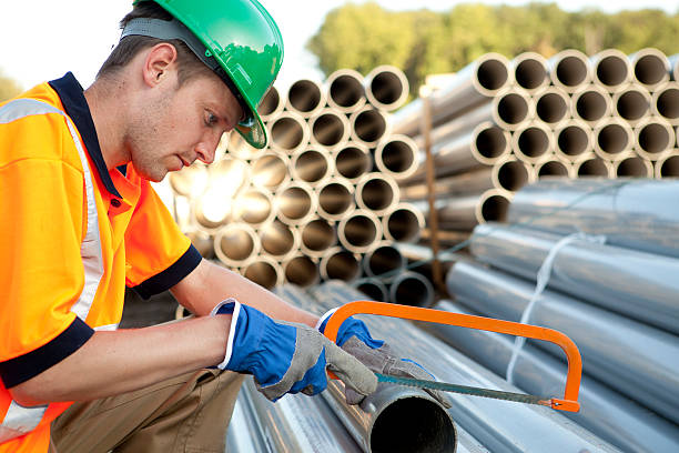 poseur de canalisations au travail avec tuyaux de pvc. eaux usées assemblée. - pipefitter photos et images de collection