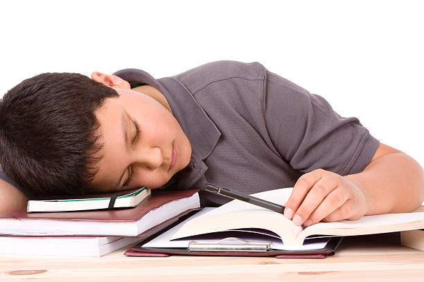 Tired male student sleeping in classroom stock photo