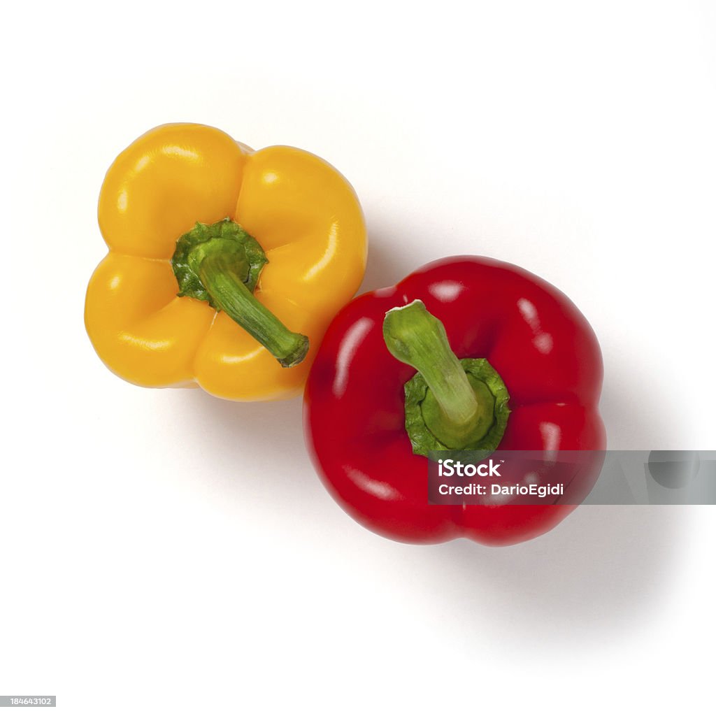 Due peperoni rossi e gialli su sfondo bianco, da sopra - Foto stock royalty-free di Cibo