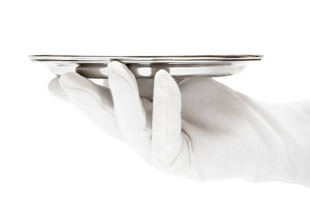 Serving Person in white gloves holding a silver serving tray. Isolated on a white background. formal glove stock pictures, royalty-free photos & images