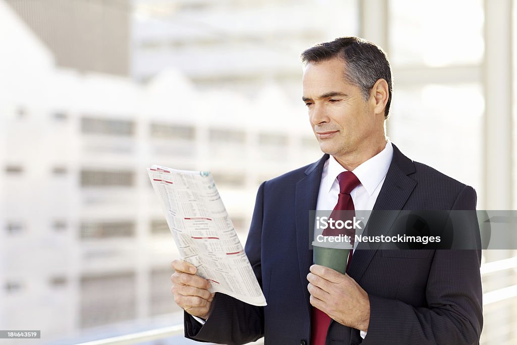 Empresario leyendo el periódico - Foto de stock de 40-49 años libre de derechos