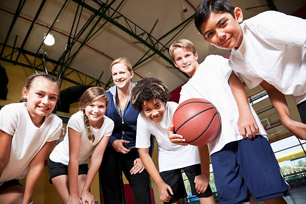 istock Group of children with coach playing basketball 184643549