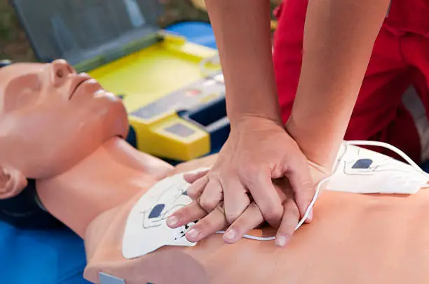 Practicing defibrillator CPR procedure on a dummyUniform your project with related images