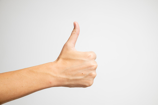 In a positive expression, a thumbs-up is showcased on a white background.