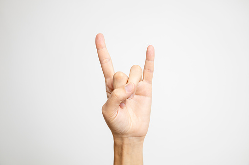 The iconic Rock and Roll hand symbol, a gesture with raised index and pinky fingers, is prominently displayed on a clean white background.