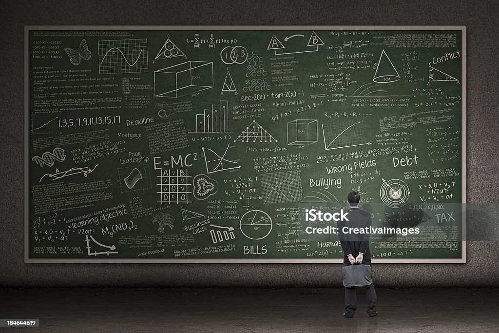 Businessman looking at hand drawn chalkboard Businessman is looking at a huge hand drawn chalkboard in a classroom Large Stock Photo