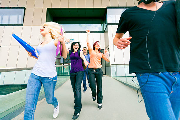 happy students walking out of college