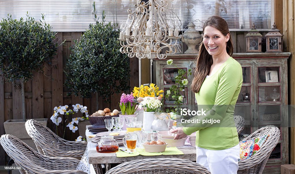 Mulher feliz junto Páscoa na Mesa de Piquenique de pequeno-almoço - Royalty-free Adulto Foto de stock