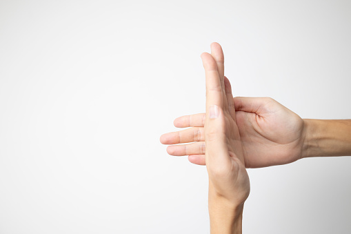 A hand pressed sideways against an open palm, creating a dynamic and expressive gesture, set against a clean white background.
