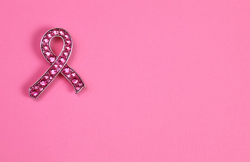 Pink Rhinestone crystal Breast Cancer Awareness ribbon on pink paper background with copy space. Horizontal image 