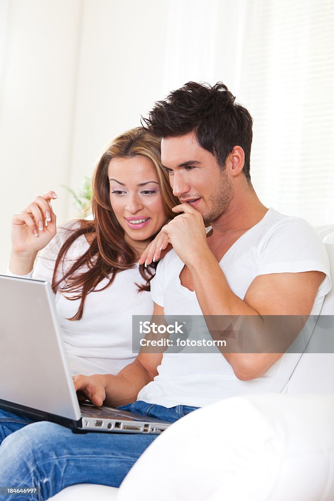 Pareja joven usando una computadora portátil - Foto de stock de Adulto libre de derechos