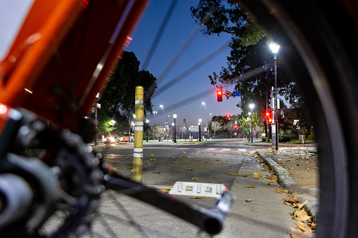 The Oroño boulevard avenue, in the zone of close to the parana river, at the morning Twilight, seen through an orange bike wheel. On June 17, 2022. Rosario city, Santa Fe province, Argentina.