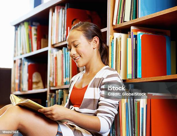 Menina Ler Livro Na Biblioteca - Fotografias de stock e mais imagens de Aluna - Aluna, Aluno da Escola Primária, Aprender