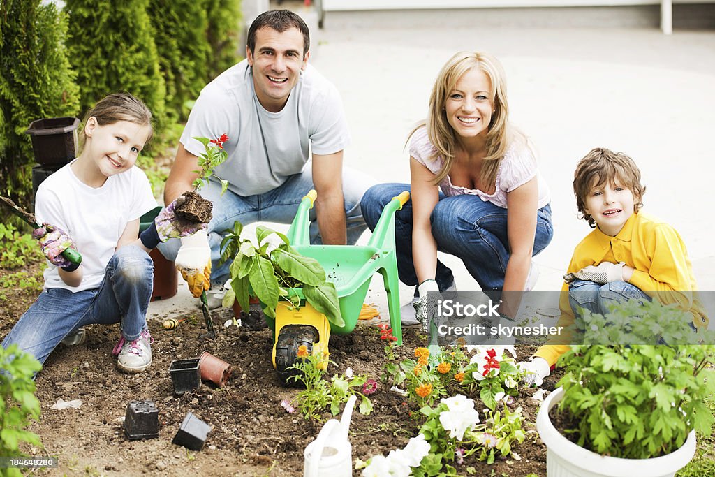 Hermosa familia disfrutando en el jardín de trabajo. - Foto de stock de Diversión libre de derechos