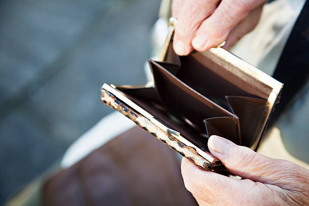 istock senior hands holding old purse 184648640