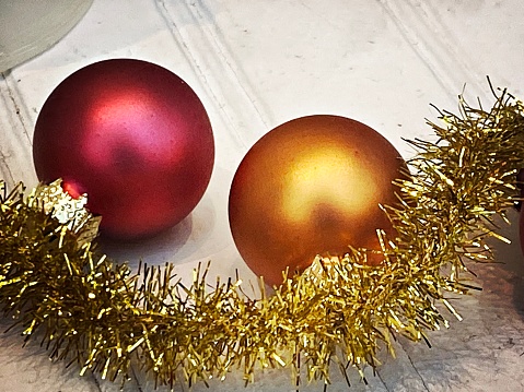 Golden festive Christmas balls decorations with ribbon on white wooden background