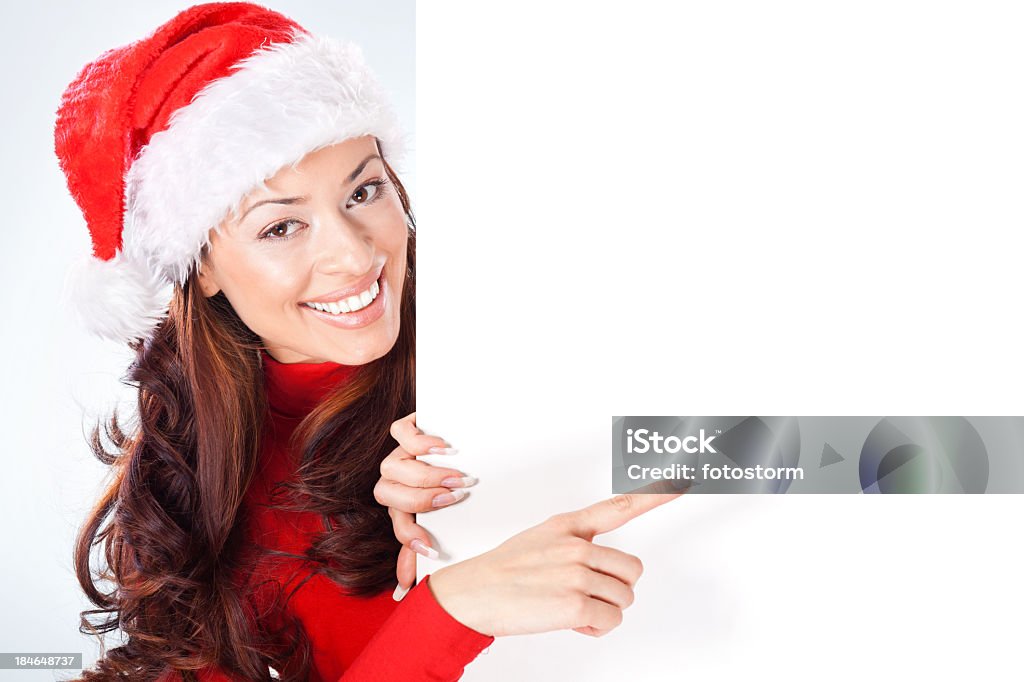 Mulher com chapéu de Papai Noel apontando no banner em branco - Foto de stock de Apontar - Sinal Manual royalty-free