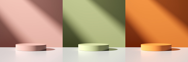 Set of cylinder pedestals or podiums with pink, orange and green colors on white table with window shade background. Abstract 3D render mockup for product display and presentation.