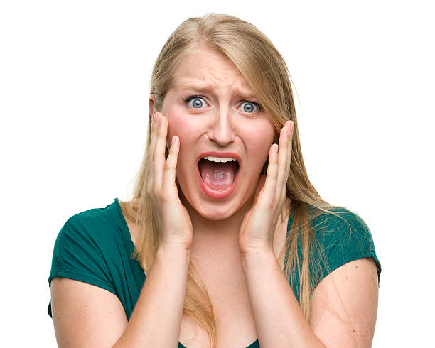 Scared Young Woman Portrait of a young woman on a white background. http://s3.amazonaws.com/drbimages/m/hb.jpg women screaming surprise fear stock pictures, royalty-free photos & images