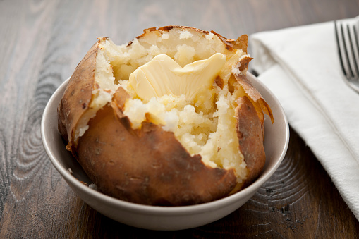 Baked potato with melting butter, horizontal.