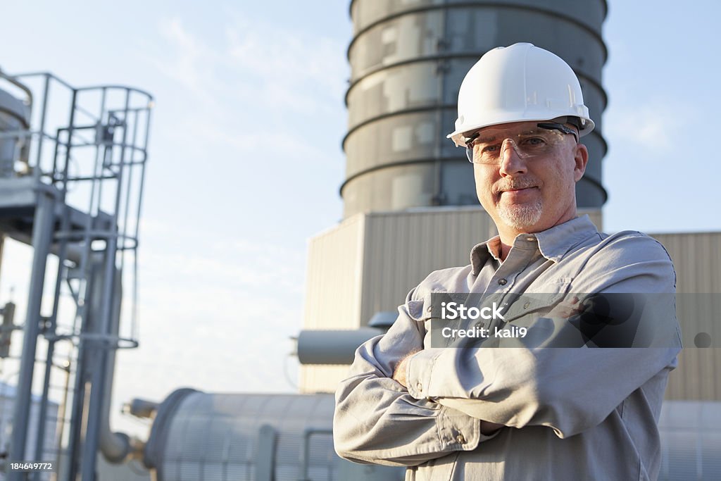 Ingegnere con Elmetto da cantiere presso Stabilimento industriale - Foto stock royalty-free di Elmetto da cantiere