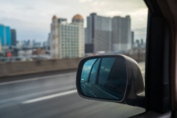 istock View from side mirror of car, sky with buildings at  Highway. 1846498201