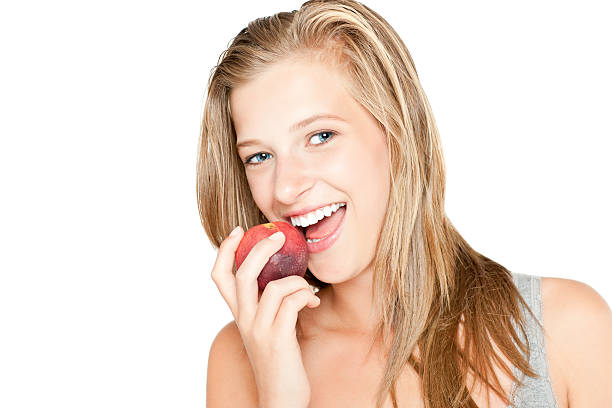 istock Beautiful girl with a peach isolated on white 184650296