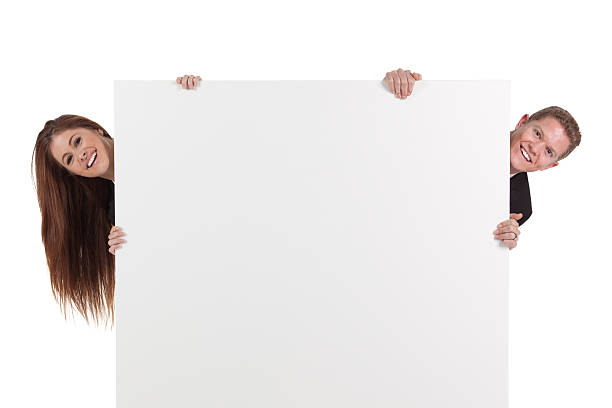istock Business couple peeking behind from a placard 184650373