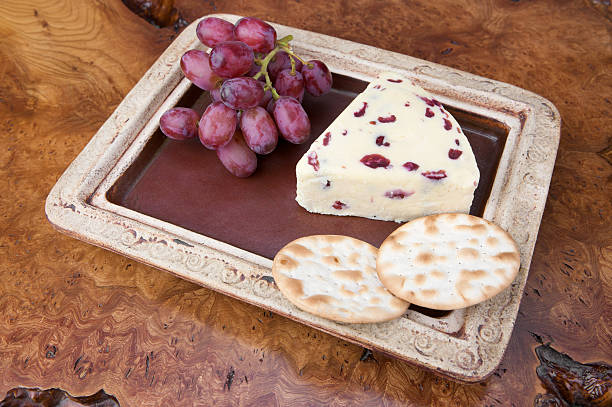 assiette de fromage de wensleydale avec des canneberges, des biscuits salés et de raisin eau - wensleydale photos et images de collection